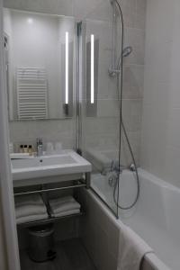 a bathroom with a shower and a sink and a tub at Les Terrasses Poulard in Le Mont Saint Michel