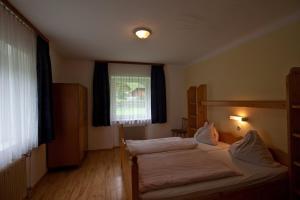 sypialnia z 2 łóżkami i oknem w obiekcie Gasthof Jaegerwirt w mieście Zederhaus