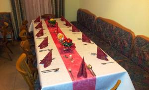 ツェーダーハウスにあるGasthof Jaegerwirtの赤いナプキンとナプキンの長テーブル