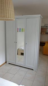 einen weißen Schrank mit einem Spiegel im Zimmer in der Unterkunft Fanny in Wittlingen