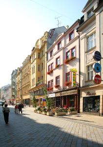 a city street with buildings and people walking on the street at Hotel Kavalír in Karlovy Vary