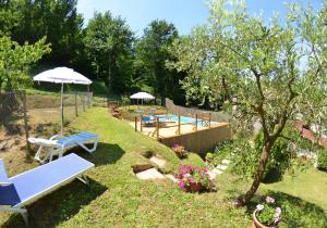 un jardín con bancos, sombrillas y una mesa en La Piccola Margherita, en Capannori