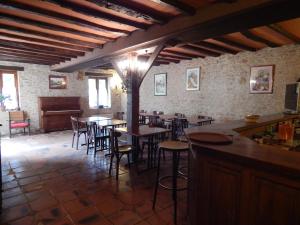 a restaurant with tables and chairs and a piano at Hotel du Parc in Thonac