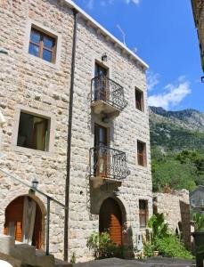 a stone building with balconies on the side of it at Apartments Linda in Drasnice