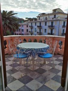 stół i krzesła na balkonie z widokiem na budynek w obiekcie Dante Flexyrent Apartment w Rapallo