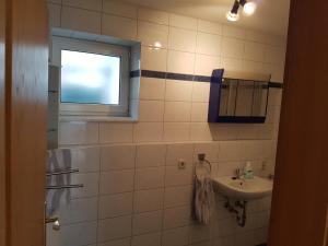 La salle de bains est pourvue d'un lavabo et d'une fenêtre. dans l'établissement Ferienwohnung Kramer, à Kippenheim