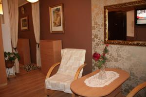 a living room with a table and a chair at Apartament Manhattan w Olsztynie in Olsztyn
