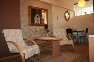 a living room with two chairs and a table and a mirror at Apartament Manhattan w Olsztynie in Olsztyn