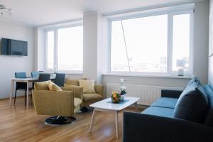 sala de estar con sofá, sillas y ventanas en Seaport Apartment, en Tallin