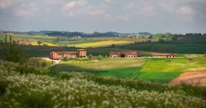 a house in the middle of a field of grass at Tenuta Montemagno Relais & Wines in Montemagno