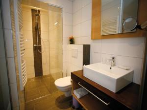 ein Bad mit einem Waschbecken, einem WC und einer Dusche in der Unterkunft Hotel Diana in Pörtschach am Wörthersee