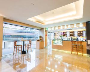 un ristorante con sedie e un bar in un edificio di Metropark Hotel Mongkok a Hong Kong