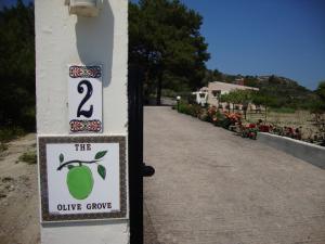a sign that reads the olive groove on a building at The Olive Grove Villa Private Pool with star links WiFi in Theologos +29 photos