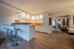 a kitchen and living room with a counter and chairs at Hills Park Luxury Apartment in Vilnius