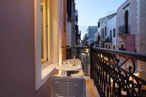 a table and chairs on a balcony of a building at Consolato Boutique in Chania