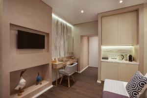 a living room with a fireplace and a kitchen at Consolato Boutique in Chania