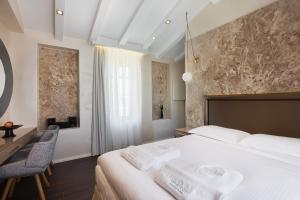 a bedroom with a large white bed and a desk at Consolato Boutique in Chania Town +30 photos
