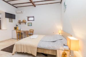 a bedroom with a large bed and a kitchen at Stari Grad in Krk