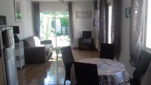 a living room with a table and chairs and a couch at Le Saint Victor in Mirabel-aux-Baronnies