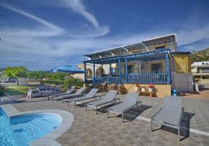 a group of lounge chairs and a swimming pool at Emporios Bay Hotel in Emporeios