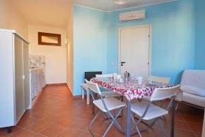 a dining room with a table and white chairs at Residence Favignana in Favignana
