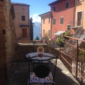 un tavolino e una sedia su un balcone con edifici di Casa Nadia a San Zeno di Montagna