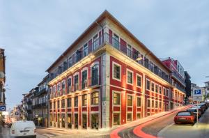 a building on a street with cars parked in front of it at Exe Almada Porto in Porto