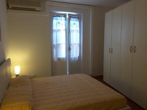 ein Schlafzimmer mit einem Bett vor einem Fenster in der Unterkunft Appartamento Poggio Romantico in Marciana