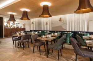 une salle à manger avec des tables, des chaises et des lumières dans l'établissement Exe Almada Porto, à Porto