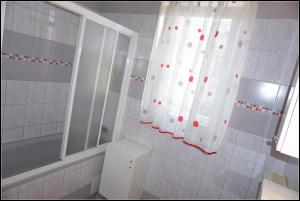 a bathroom with a shower and a toilet and a window at Orlando's Apartments OJ in Izola