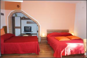 a bedroom with two beds and a mirror at Orlando's Apartments OJ in Izola