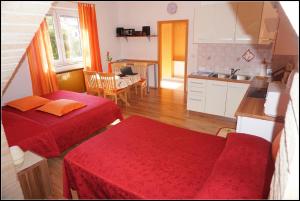 a living room with two beds and a kitchen at Orlando's Apartments OJ in Izola