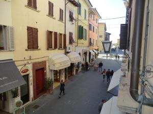 Un groupe de personnes marchant dans une rue avec des bâtiments dans l'établissement Casa Pucci, à Pietrasanta