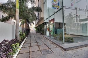 an empty street with palm trees and a building at Hotel Sai Miracle in Shirdi