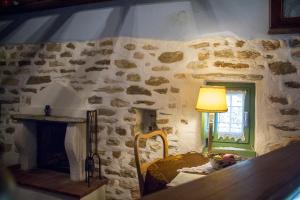 a bedroom with a stone wall with a bed and a window at Efipoi in Pinakátai