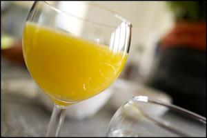 a glass of orange juice sitting on a table at Rooseboom22 in Aartrijke