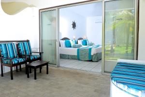 a hotel room with a bed and a chair at Voyager Beach Resort in Mombasa