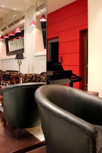 een woonkamer met een piano en een stoel bij Galaxy Hotel in Kalamata