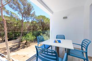 a table and chairs on a balcony with a view of the beach at Pinos Playa Suites in Playa Migjorn