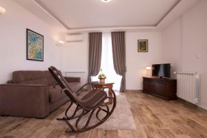 a living room with a chair and a couch at Guest House Medin in Petrovac na Moru