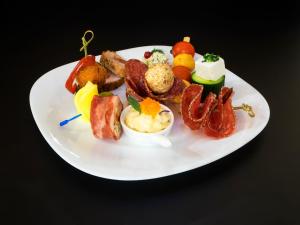 a white plate of food on a black table at Hotel Emi in Mihail Kogălniceanu