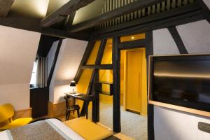 a room with a bed and a window at Hotel Le Colombier Suites in Colmar