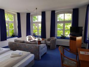Hotel Havenhaus في بريمن-فيغِزاك: غرفة في الفندق مع أريكة وتلفزيون