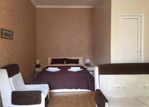 1 Schlafzimmer mit einem Bett und 2 Stühlen in der Unterkunft Guest House Rampa in Tbilisi City