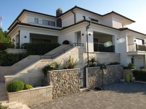 uma casa branca com escadas e uma cerca em Villetta Mia em Njivice