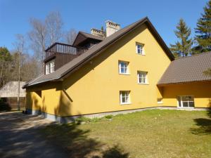 a yellow house with a black roof at Viva Pirita Hostel in Tallinn