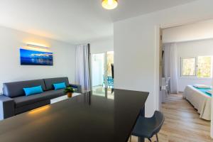 een woonkamer met een bank en een tafel bij Pinos Playa Suites in Playa Migjorn