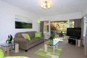 uma sala de estar com um sofá e uma televisão de ecrã plano em Durie Vale Retreat em Whanganui