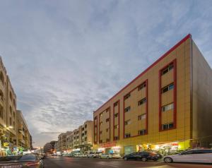 ein Gebäude in einer Stadtstraße mit parkenden Autos in der Unterkunft Royal Tulip Hotel LLC in Dubai