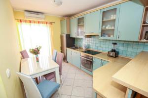 a kitchen with blue cabinets and a table with chairs at Apartmani Ljubica in Poreč